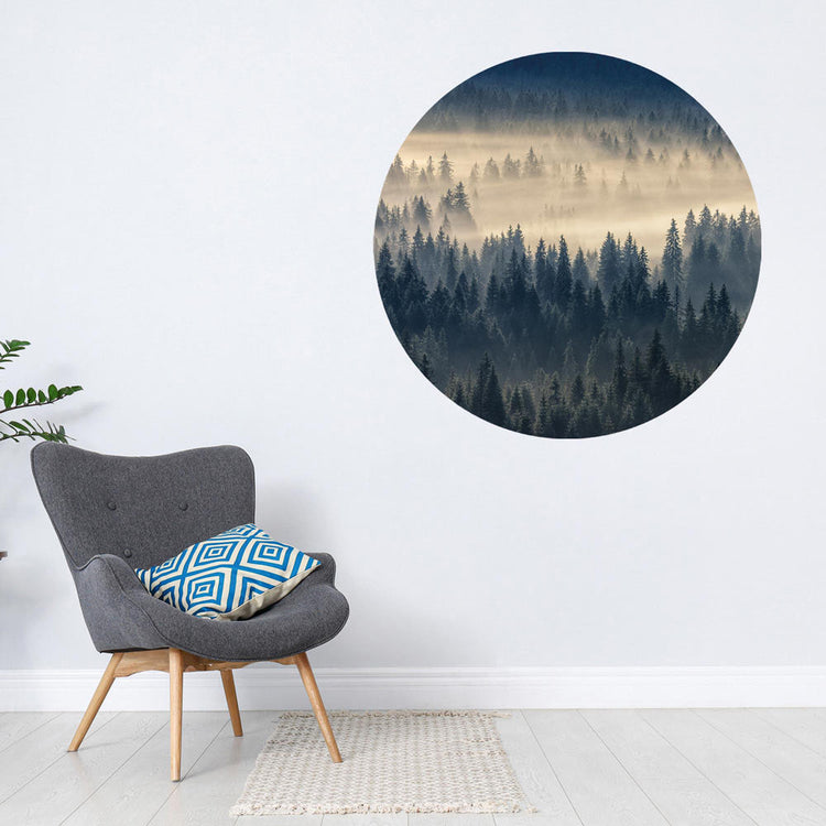 Großansicht eines runden Wandaufklebers mit einem Motiv vom Nebelwald. Das Bild schafft einen 3D Effekt und sorgt für eine Tiefe. Als Dekoidee ist es an einer weissen Wand verklebt über einem grauen Sessel.