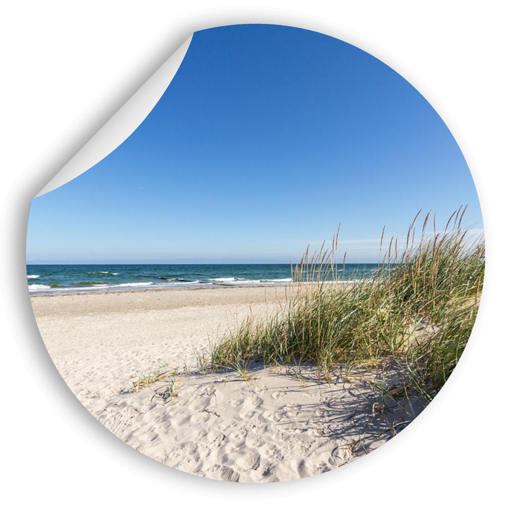 Großansicht eines runden Wandaufklebers mit einem Motiv von Ostseedünen, Strand und dem Meer. Das Bild schafft einen 3D Effekt und sorgt für eine Tiefe. An einer Ecke ist es etwas aufgerollt.