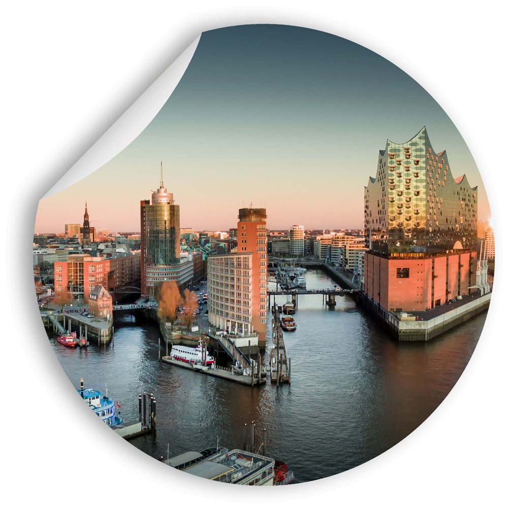 Wandsticker mit einem atemberaubenden Blick auf die Hamburger Hafencity und die Elbphilharmonie im Abendlicht.