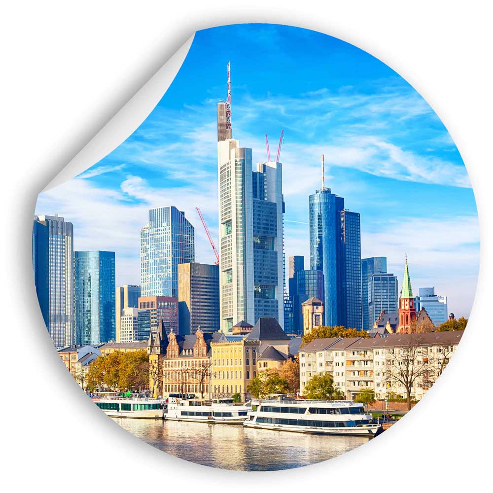 Rundes Wandbild mit der Skyline von Frankfurt am Main. Moderne Hochhäuser und historischer Stadtkern spiegeln sich im Wasser.