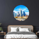 Rundes Wandbild mit der Skyline von Frankfurt am Main, stilvoll über einem Bett mit Rattan-Kopfteil auf dunkler Wand dekoriert.