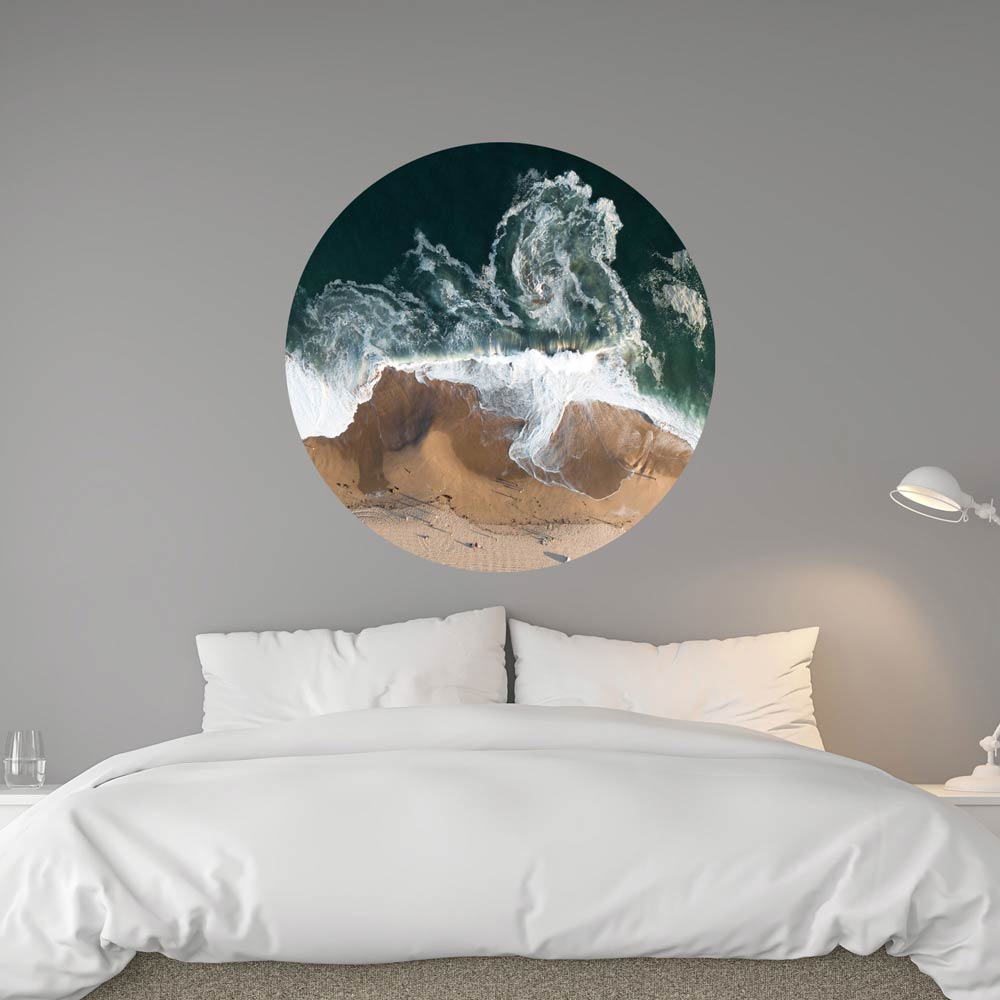 Luftaufnahme von Wellen, die an einem Sandstrand brechen. Das Bild ist in einem modernen Schlafzimmer an der Wand angebracht.