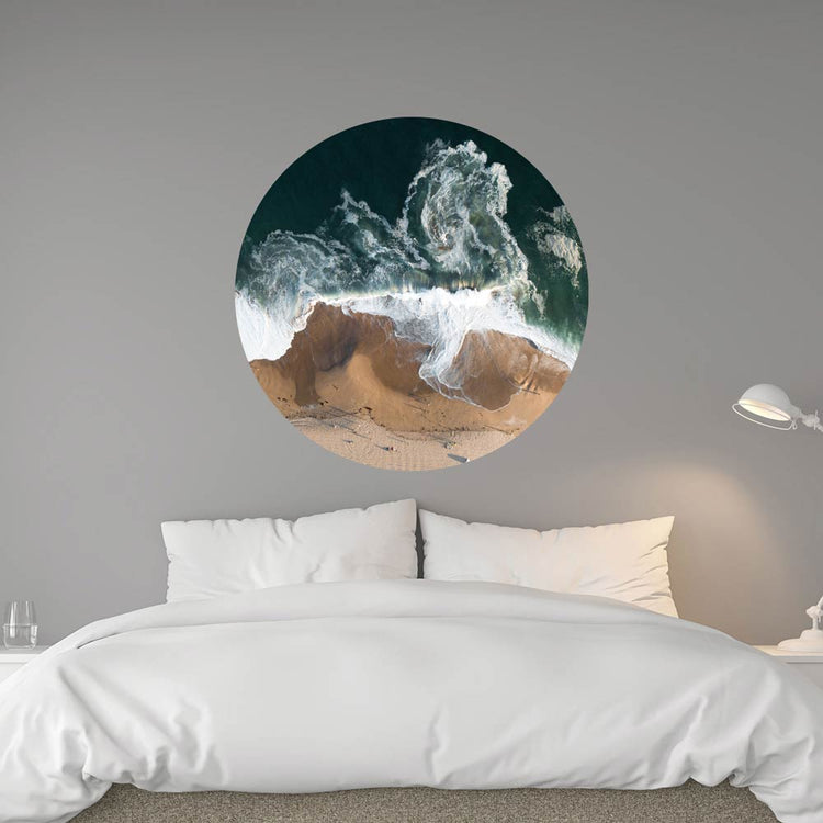 Luftaufnahme von Wellen, die an einem Sandstrand brechen. Das Bild ist in einem modernen Schlafzimmer an der Wand angebracht.