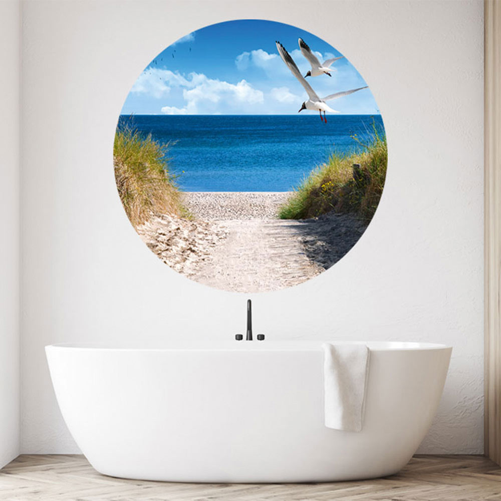 Großansicht eines runden Wandaufklebers mit einem Motiv am Strand mit Möwen. Das Bild schafft einen 3D Effekt und sorgt für eine Tiefe. Als Dekoidee ist das Wandtattoo an einer weissen Wand verklebt in einem Badezimmer über der Badewanne.