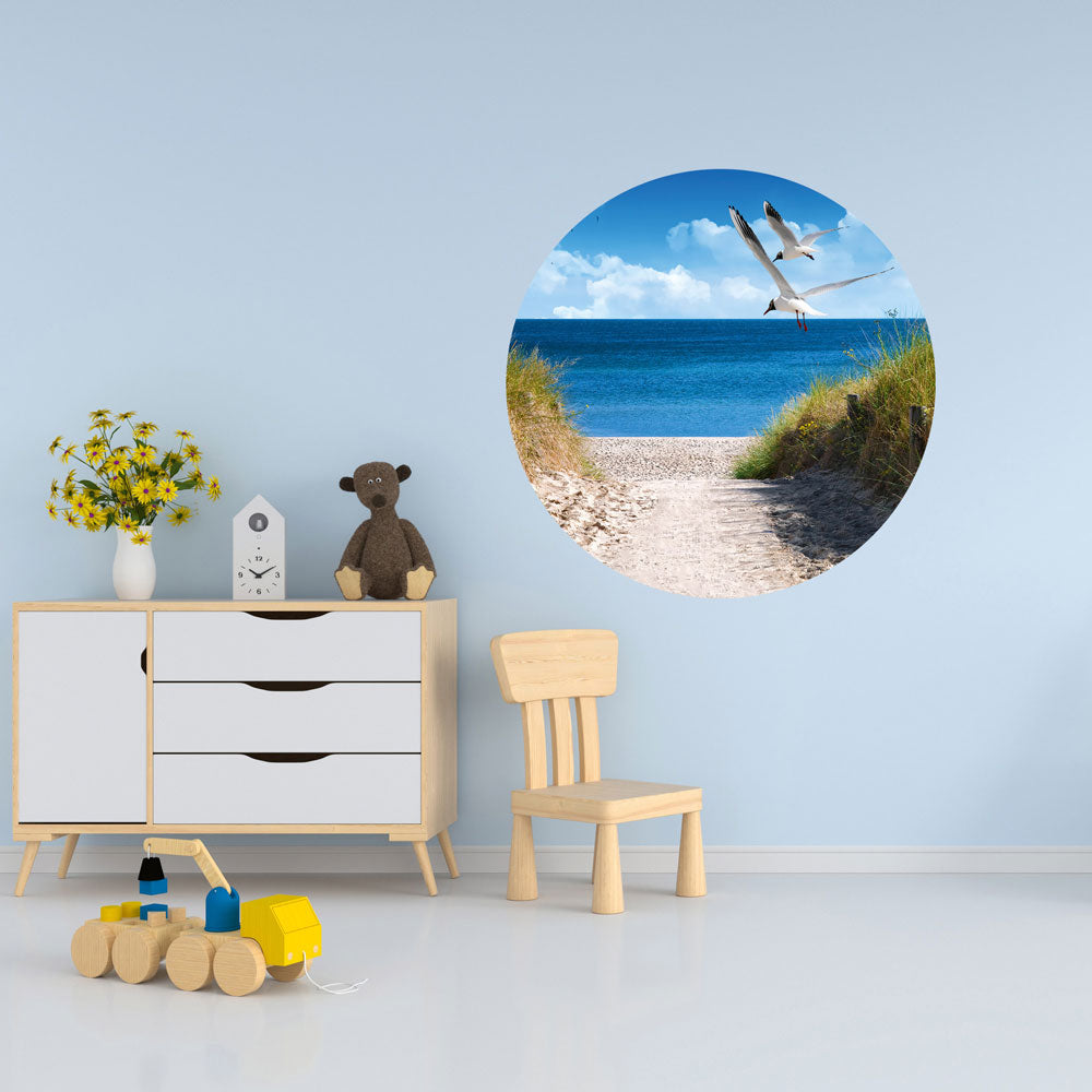 Großansicht eines runden Wandaufklebers mit einem Motiv am Strand mit Möwen. Das Bild schafft einen 3D Effekt und sorgt für eine Tiefe. Als Dekoidee ist das Wandtattoo an einer hellblauen Wand verklebt in einem Kinderzimmer.