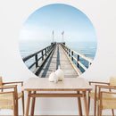 Großansicht eines runden Wandaufklebers mit einem Motiv vom Steg in der Nordsee. Das Bild schafft einen 3D Effekt und sorgt für eine Tiefe. Als Dekoidee ist es an einer weissen Wand verklebt über einem Esstisch aus Holz.