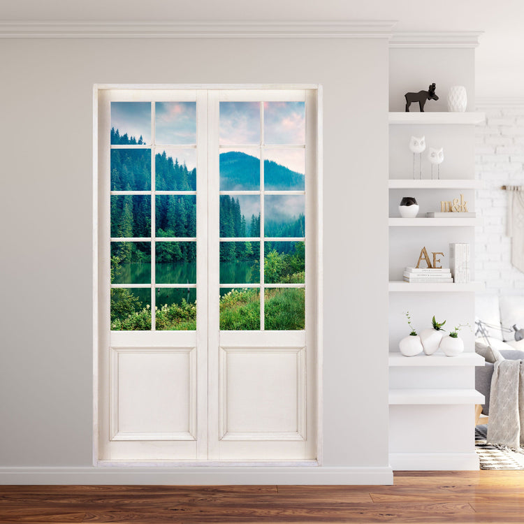Innendekoration Wandtattoo Terrassentür 120x200cm Größe und Ausblick in die wunderbare Natur auf "See am Tannenwald", neben einem Regal im Wohnzimmer.