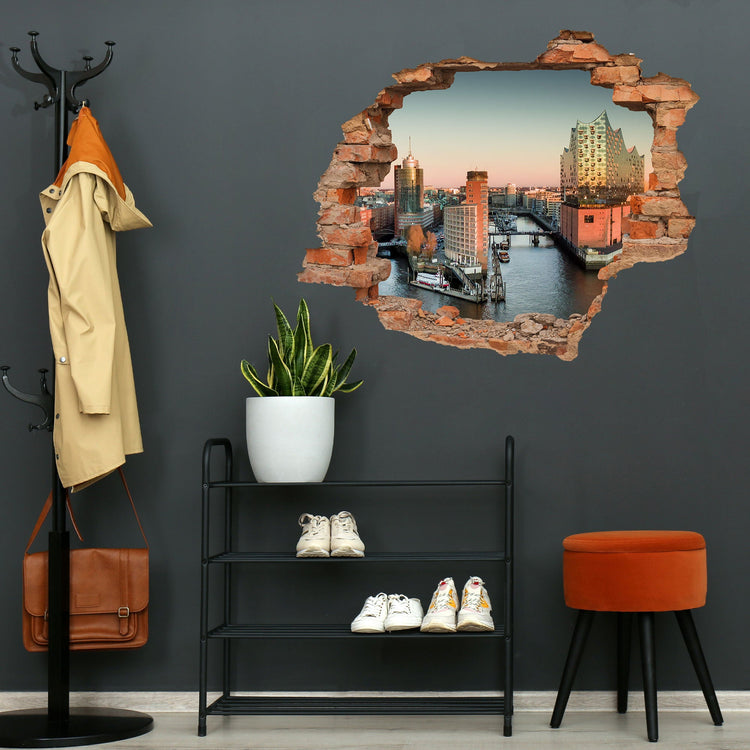 3D-Wandtattoo mit Backstein-Effekt und Blick auf die Elbphilharmonie in Hamburg, angebracht in einem modernen Flur mit dunkler Wandfarbe, Schuhregal und Pflanze.