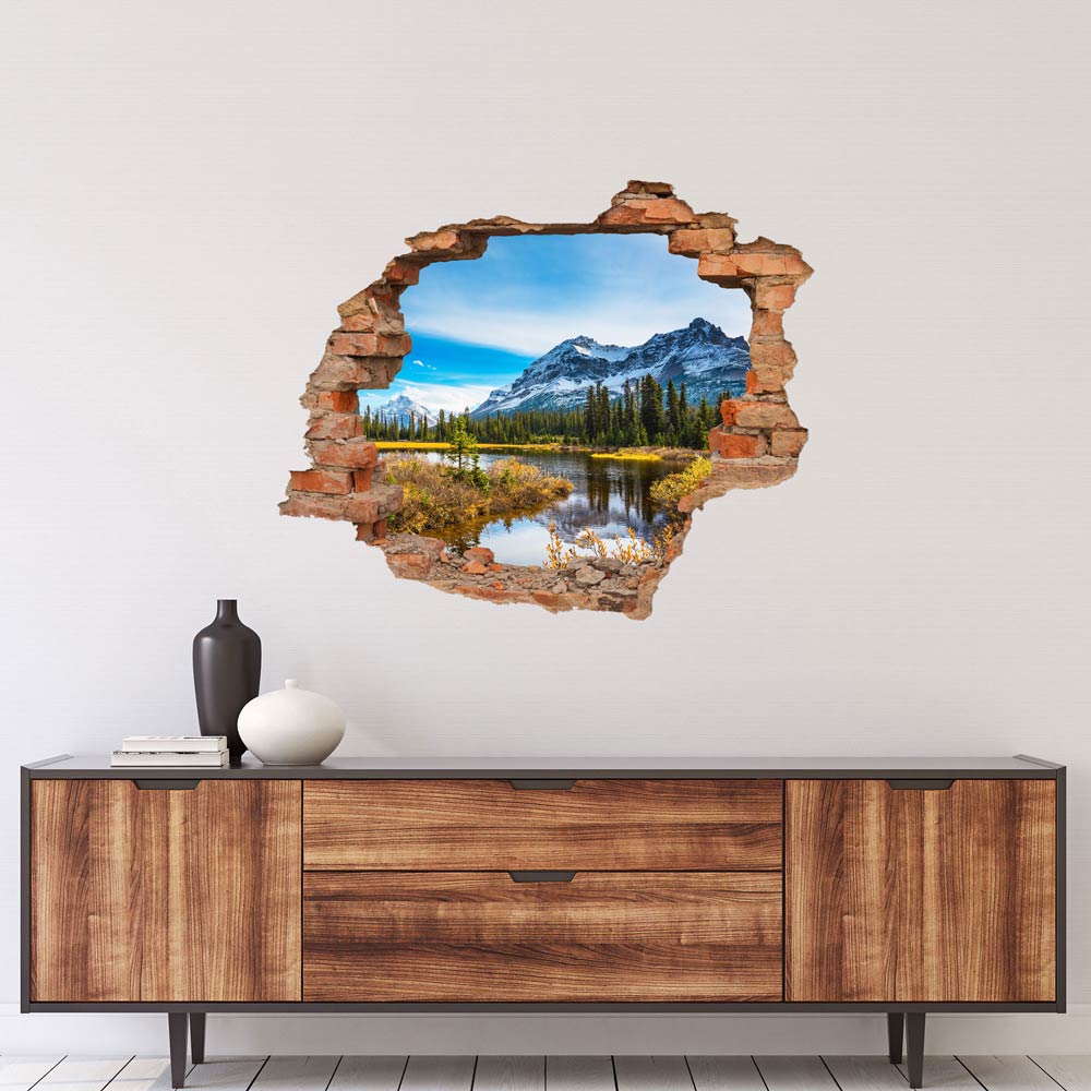 Wandaufkleber - Wanddurchbruch "Italienische Berge" über einer Kommode in Holzoptik.