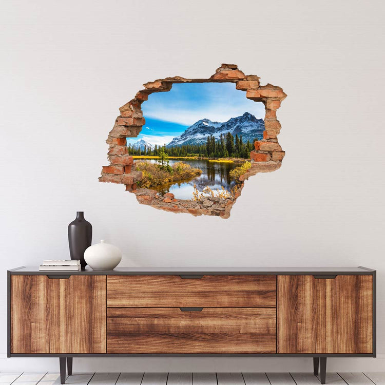 Wandaufkleber - Wanddurchbruch "Italienische Berge" über einer Kommode in Holzoptik.